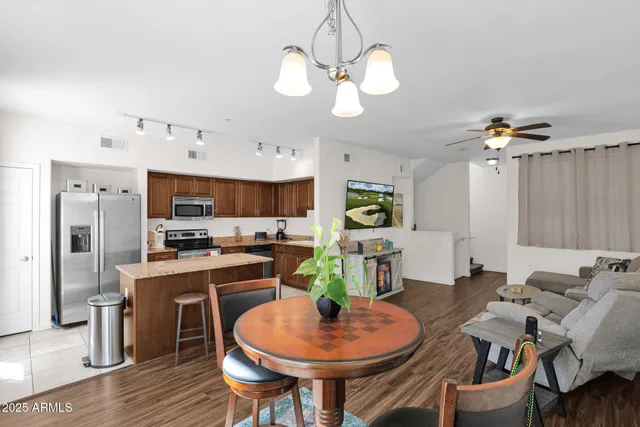 a dining room with wooden floor a chandelier a wooden table and chairs