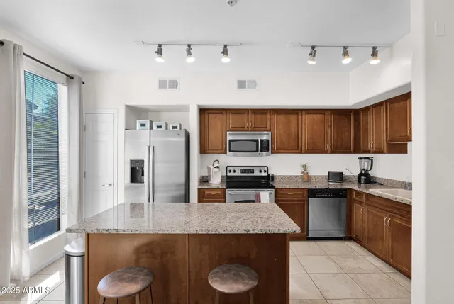 a kitchen with stainless steel appliances granite countertop a sink a stove and cabinets