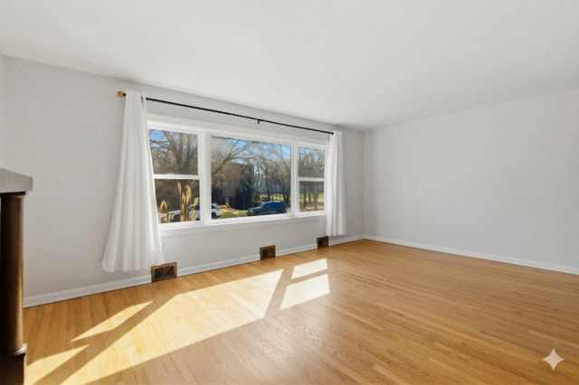 556 Barton Avenue, Unit 2 Evanston, IL 60202 - Photo 3 of 21 a view of an empty room with wooden floor and a window