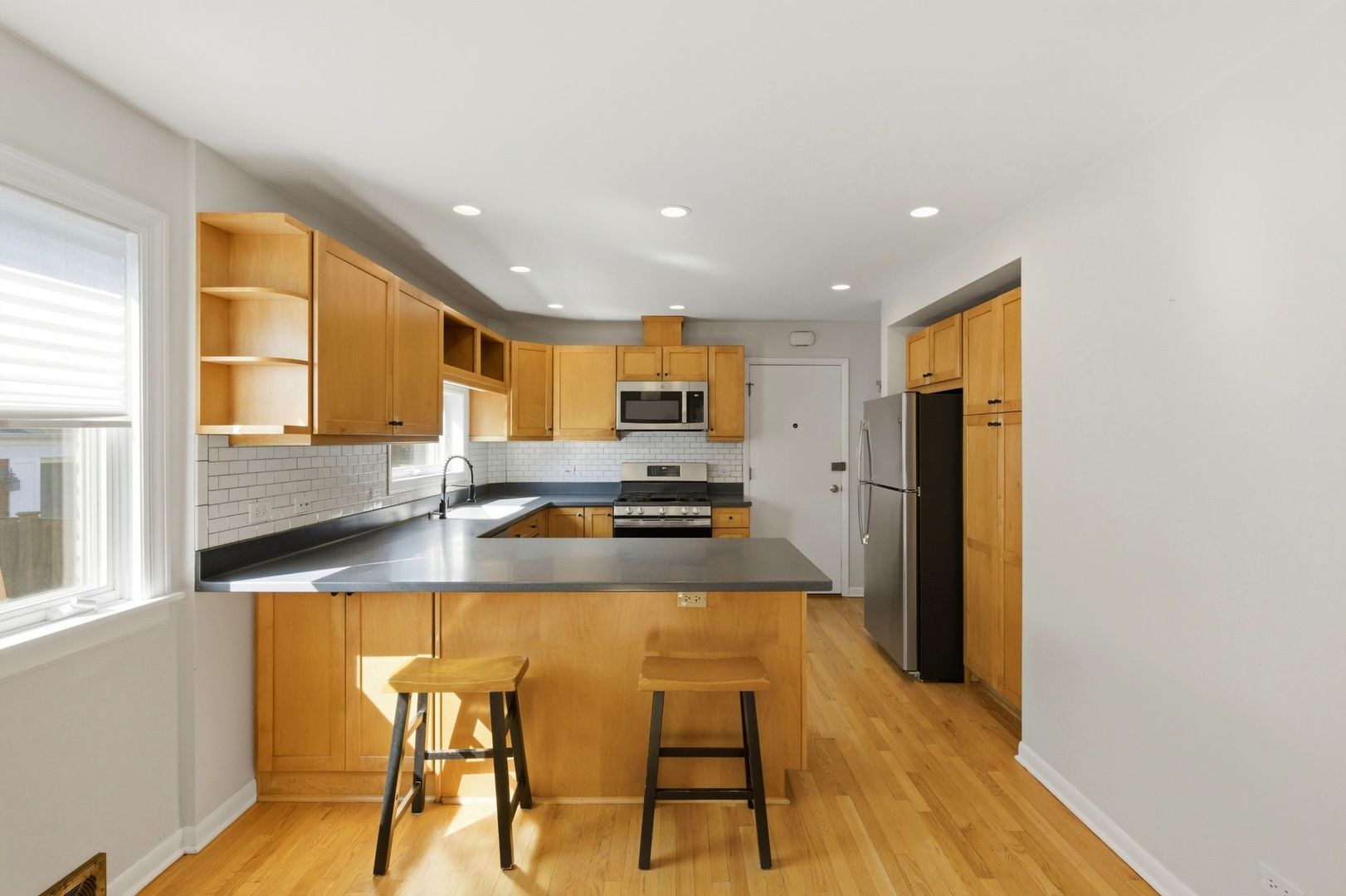 556 Barton Avenue, Unit 2 Evanston, IL 60202 - Photo 6 of 21 a kitchen with stainless steel appliances granite countertop a stove a sink a refrigerator white cabinets and wooden floor