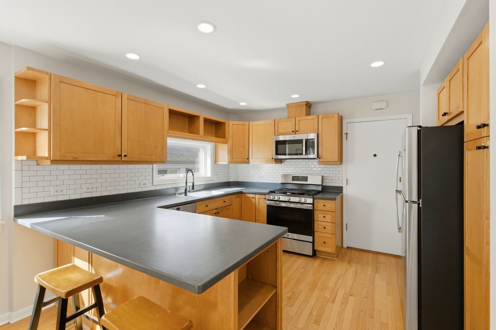 556 Barton Avenue, Unit 2 Evanston, IL 60202 - Photo 9 of 21 a kitchen with stainless steel appliances granite countertop a sink a stove and a refrigerator