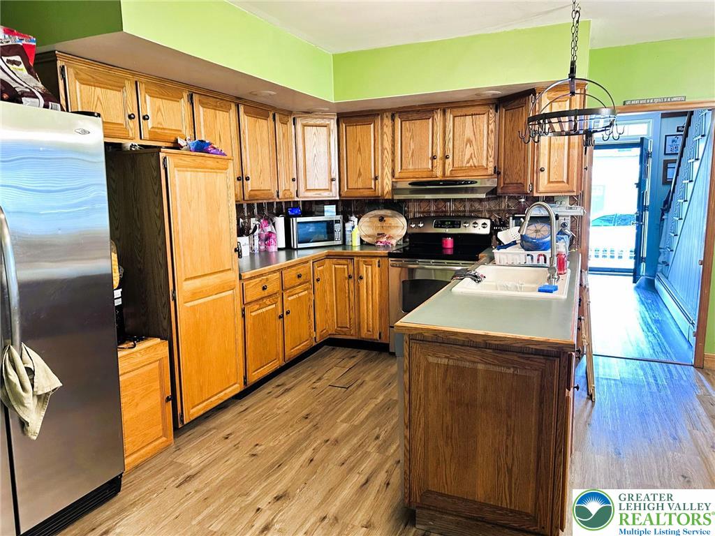 505 Penn Street Bath, PA 18014 - Photo 7 of 23 a kitchen with stainless steel appliances granite countertop a refrigerator a sink dishwasher a stove and white cabinets with wooden floor