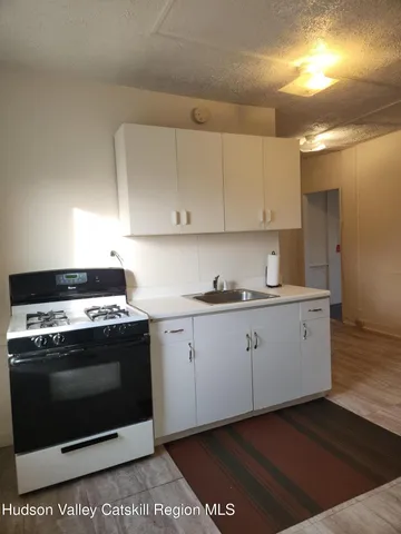 a kitchen with granite countertop white cabinets and stainless steel appliances