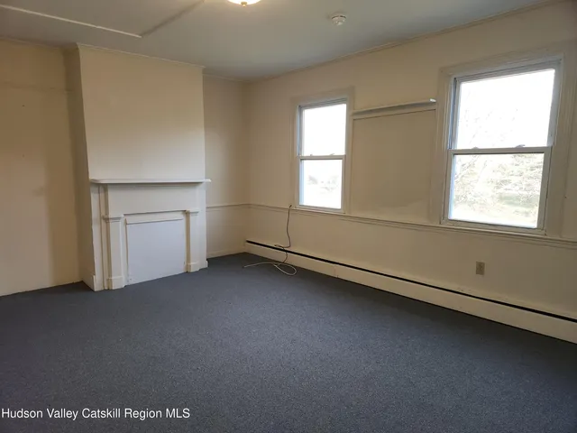 an empty room with a fireplace and window