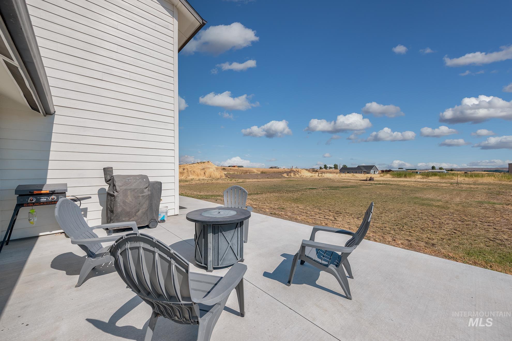 1049 Price Road Weiser, ID 83672 - Photo 33 of 47 Concrete patio extending from the white horizontal siding of the property, offering an expansive outdoor space