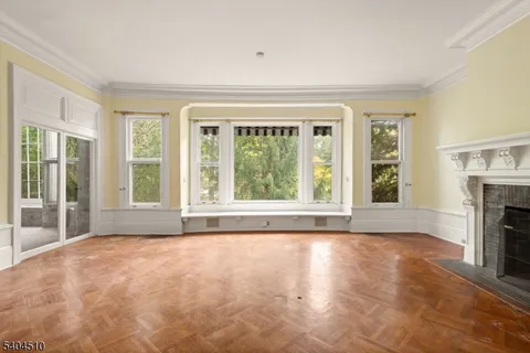 a view of an empty room with a window and a fireplace