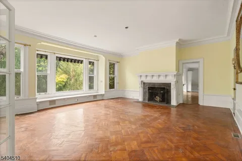 a view of an empty room with a fireplace and a window