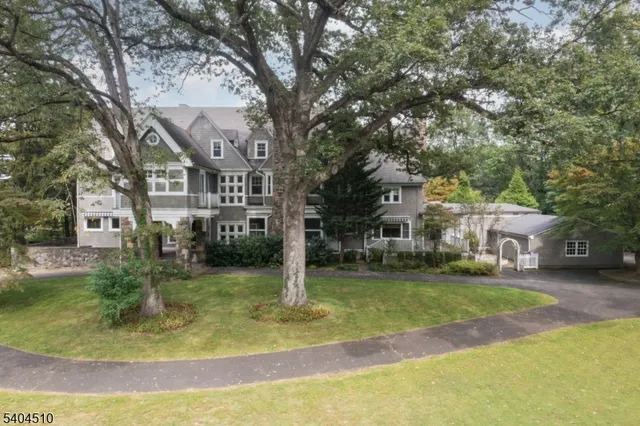 a view of a house with a big yard and large trees