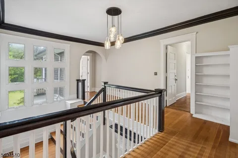 a view of a hallway with wooden floor and staircase