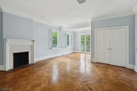 a view of empty room with wooden floor and fireplace