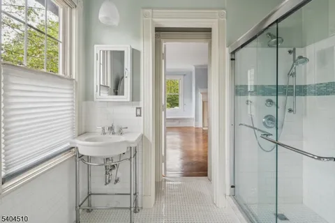a bathroom with a sink mirror and shower