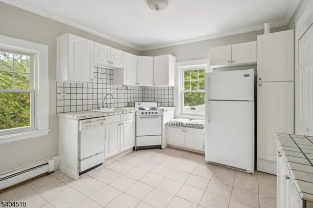 a kitchen with white cabinets and white appliances