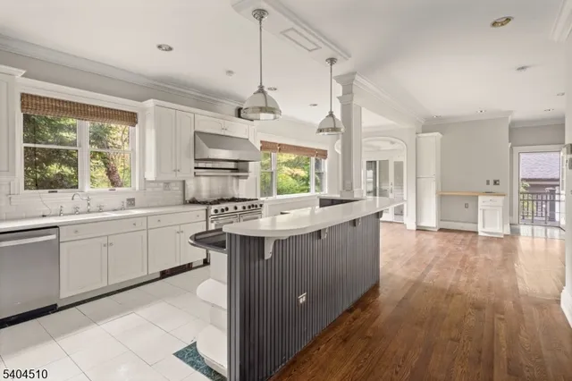 a kitchen with stainless steel appliances kitchen island hardwood floor sink stove and wooden cabinets