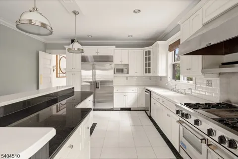 a large kitchen with stainless steel appliances granite countertop a sink and cabinets