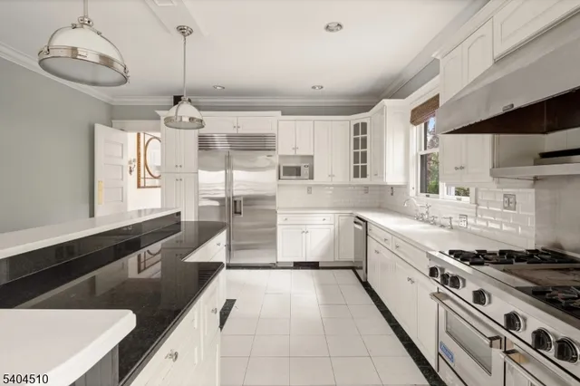 a large kitchen with stainless steel appliances granite countertop a sink and cabinets