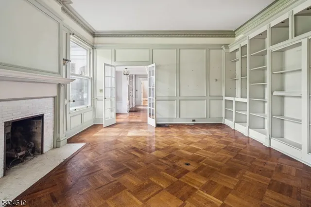 a view of an empty room with a fireplace and a window