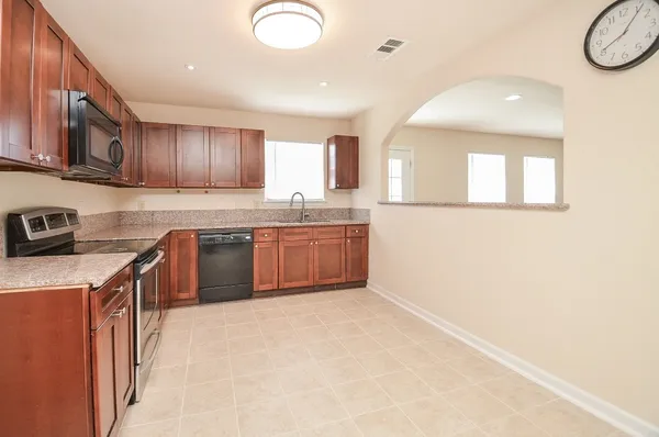 a kitchen with stainless steel appliances granite countertop a refrigerator microwave and sink