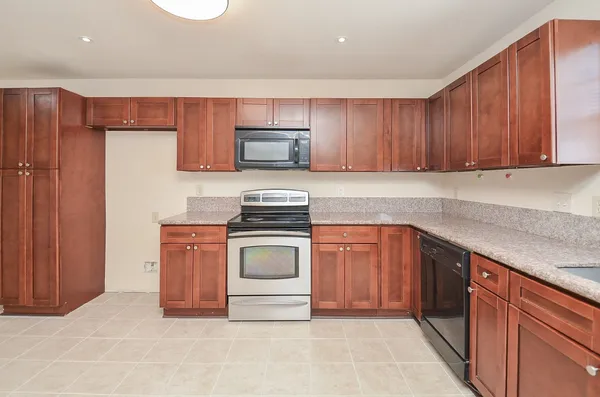a kitchen with stainless steel appliances granite countertop a stove sink and cabinets