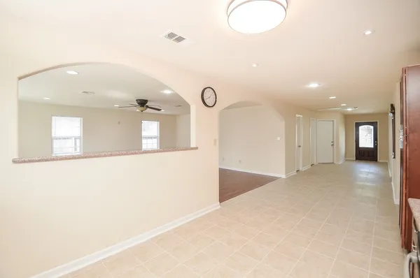 a view of an empty room with window and wooden floor