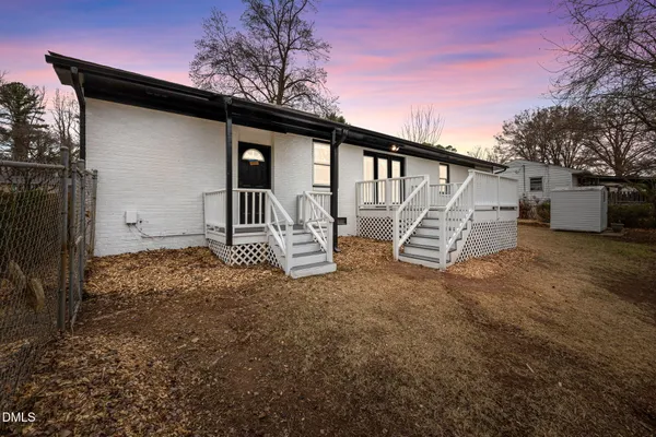 a view of a house with backyard and a tree