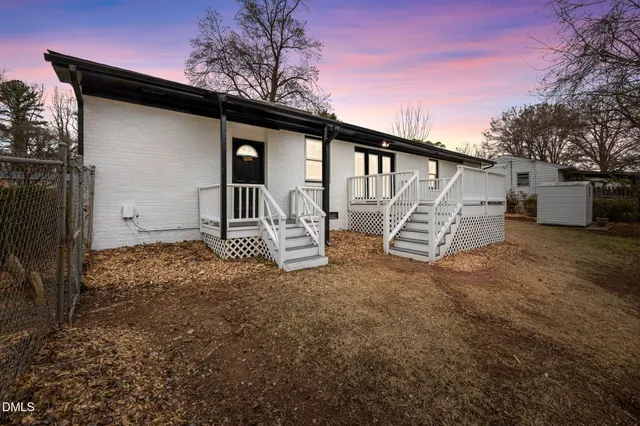 a view of a house with backyard and a tree
