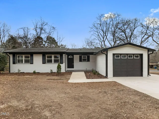 a front view of a house with a garden and garage