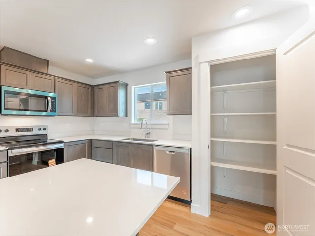 a kitchen with stainless steel appliances kitchen island granite countertop a stove and a sink