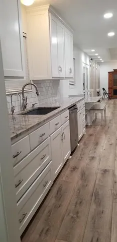 a kitchen with granite countertop white cabinets and white appliances