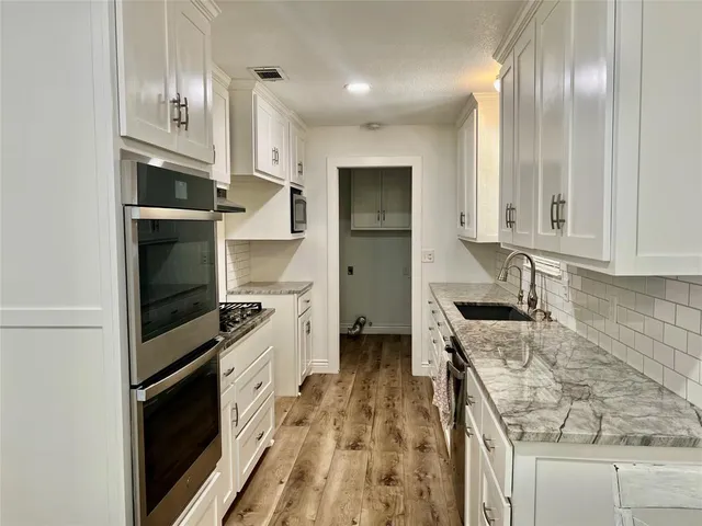 a kitchen with granite countertop stainless steel appliances and counter space