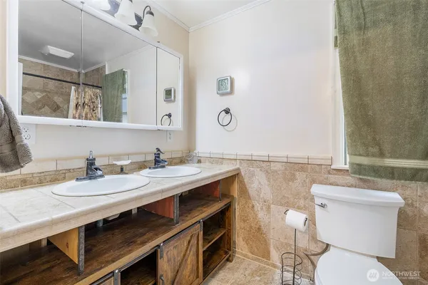 a bathroom with a sink a toilet and a mirror