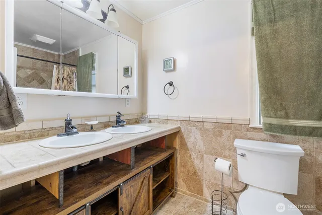 a bathroom with a sink a toilet and a mirror