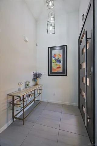 a room with chandelier fan and windows
