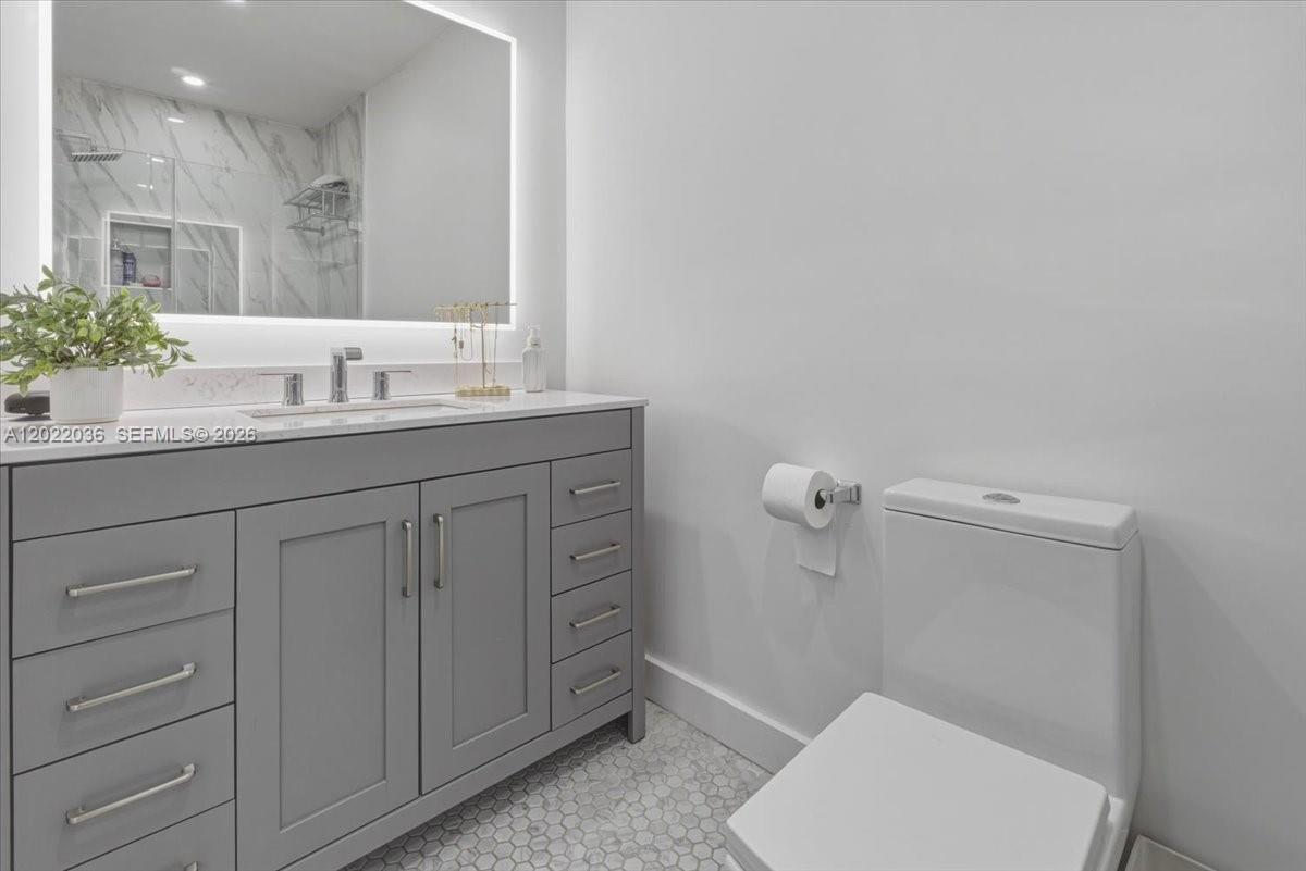 120 West 50th Street Hialeah, FL 33012 - Photo 13 of 22 a bathroom with a granite countertop sink a toilet and a mirror