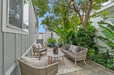 a view of a patio with couches table and chairs and potted plants
