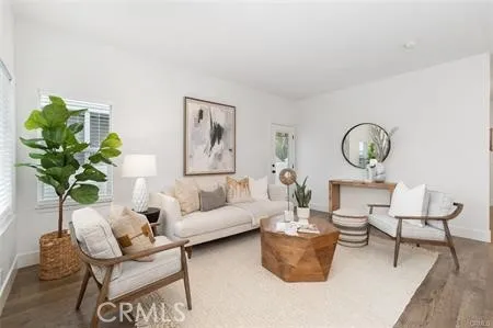 a living room with furniture a clock and a potted plant