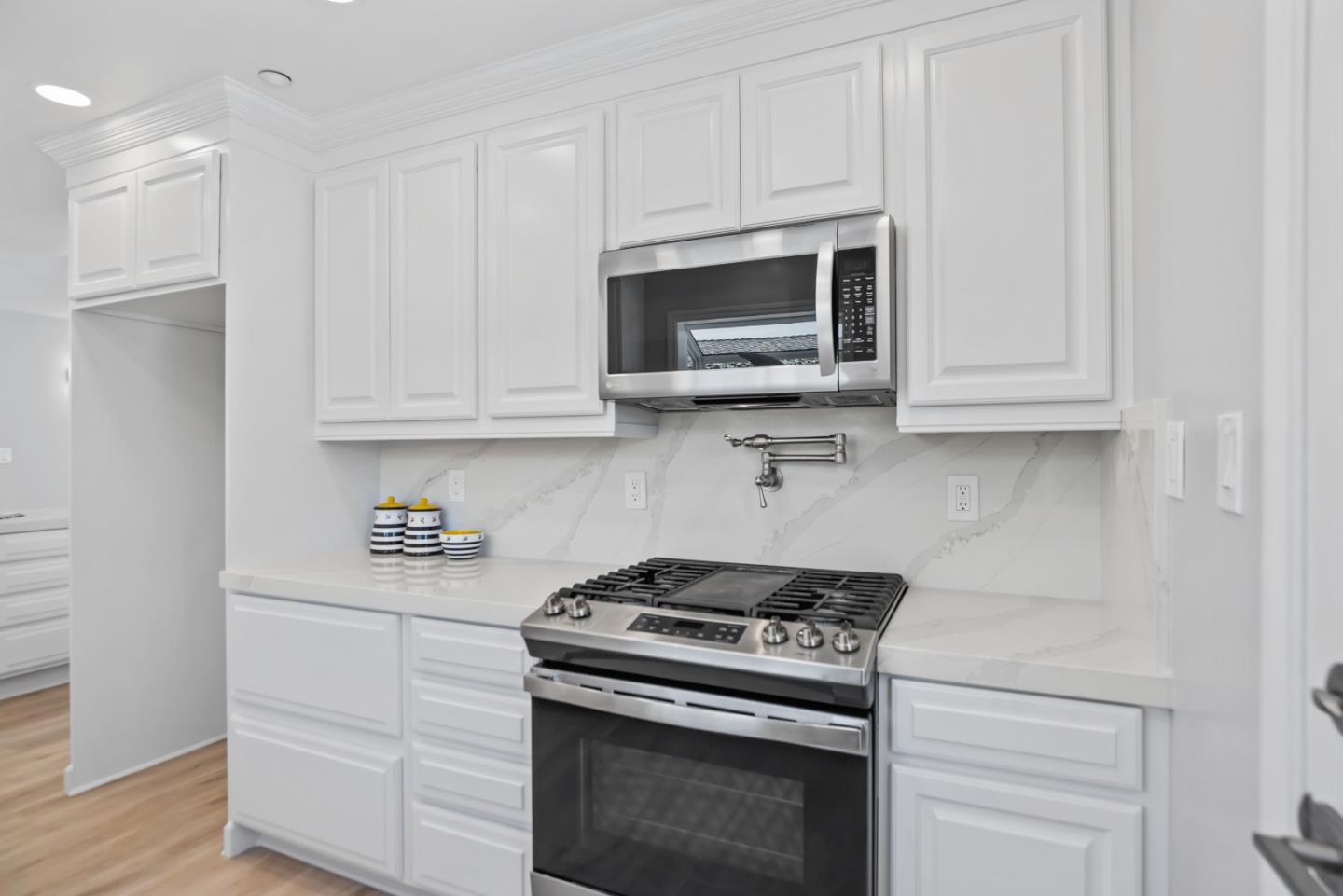 967 Chelan Drive Sunnyvale, CA 94087 - Photo 13 of 38 a kitchen with stainless steel appliances granite countertop white cabinets and a stove a oven with white countertops