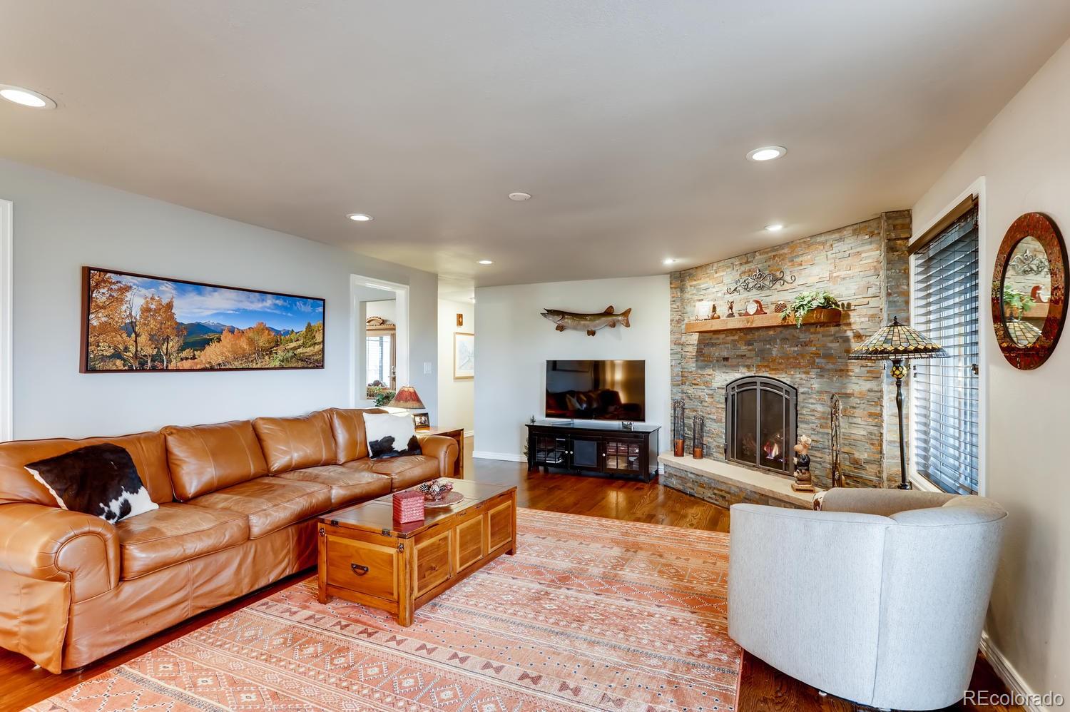 1502 Juniper Street Longmont, CO 80501 - Photo 13 of 28 a living room with furniture a flat screen tv and a fireplace