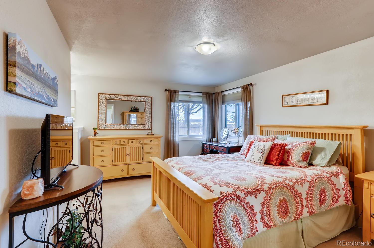 1502 Juniper Street Longmont, CO 80501 - Photo 15 of 28 a bedroom with a bed and dresser with mirror