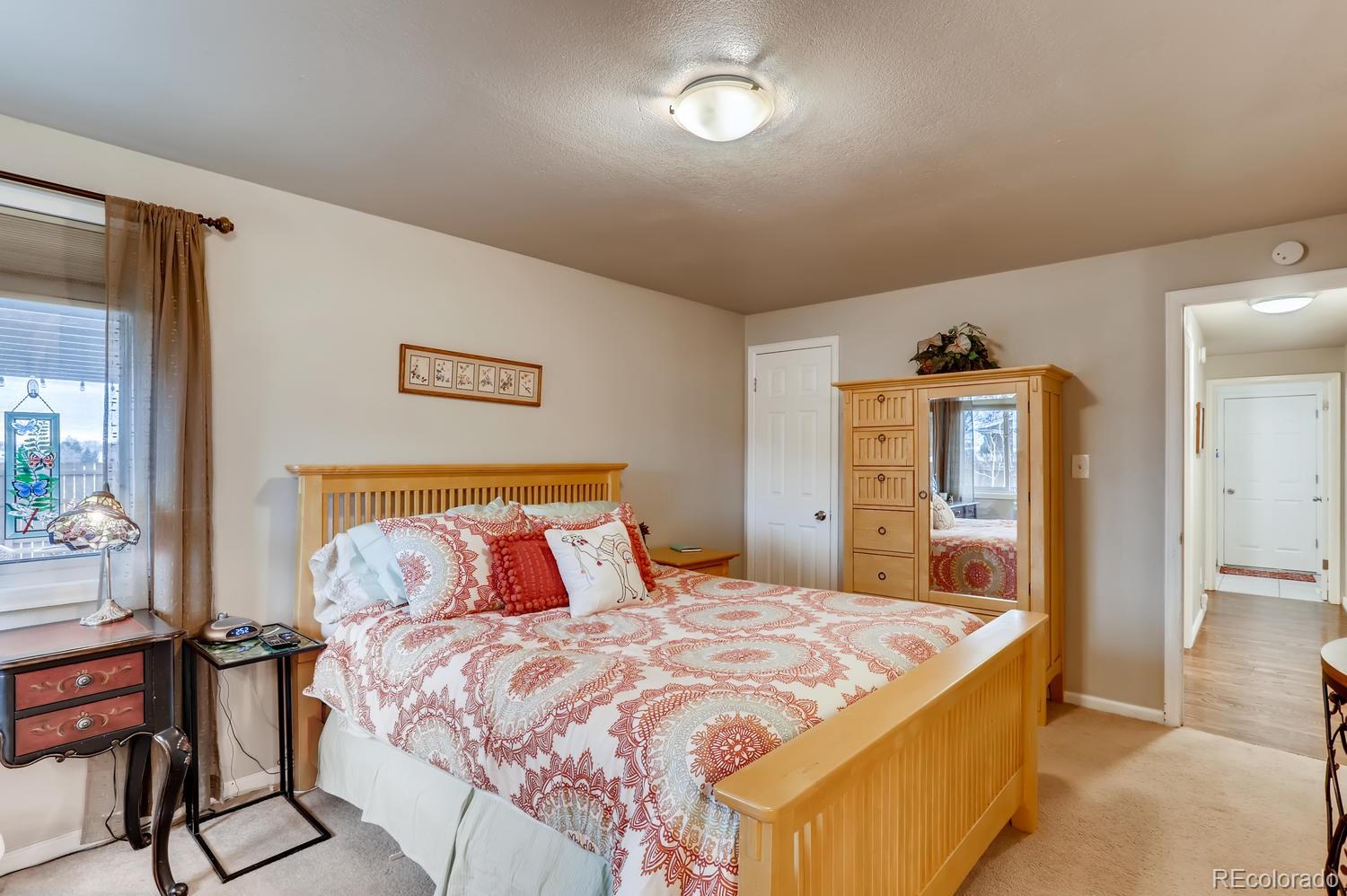 1502 Juniper Street Longmont, CO 80501 - Photo 16 of 28 a bedroom with a bed and wooden floor