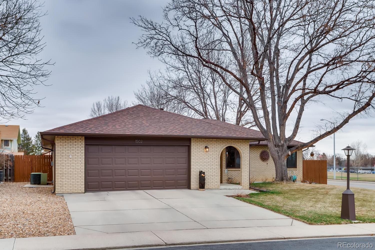 1502 Juniper Street Longmont, CO 80501 - Photo 3 of 28 a front view of a house with garden