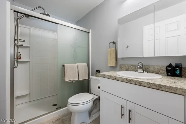 a bathroom with a granite countertop sink toilet and shower