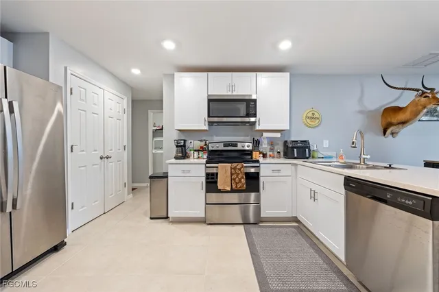 a kitchen with white cabinets and stainless steel appliances