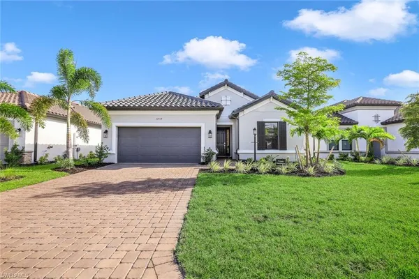 a front view of a house with a garden and yard