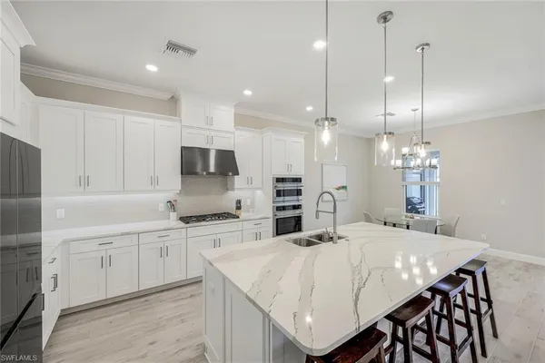 a kitchen with kitchen island granite countertop a sink a center island and cabinets