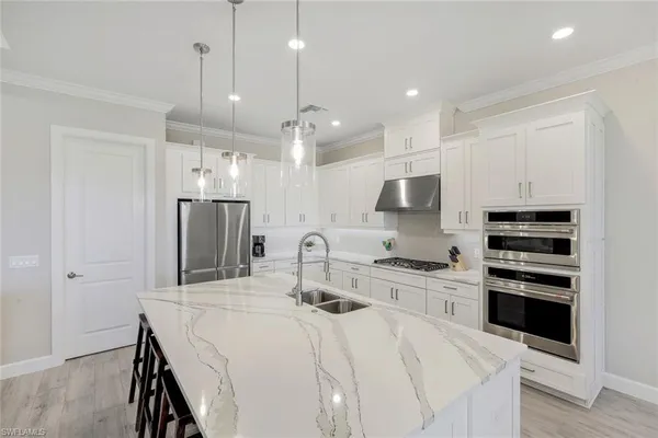 a kitchen with stainless steel appliances a stove a sink a refrigerator and cabinets