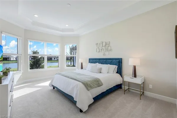 a large bed sitting in a bedroom next to a window