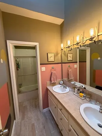 a bathroom with a granite countertop sink a mirror and shower