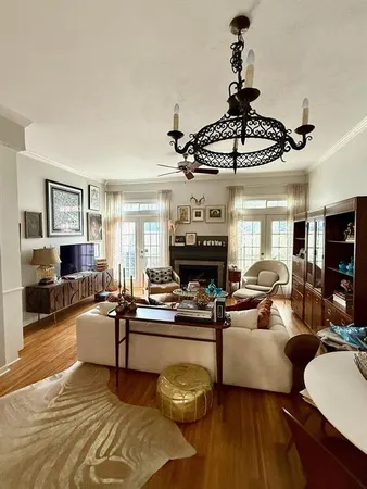 a living room with furniture a chandelier and a fireplace