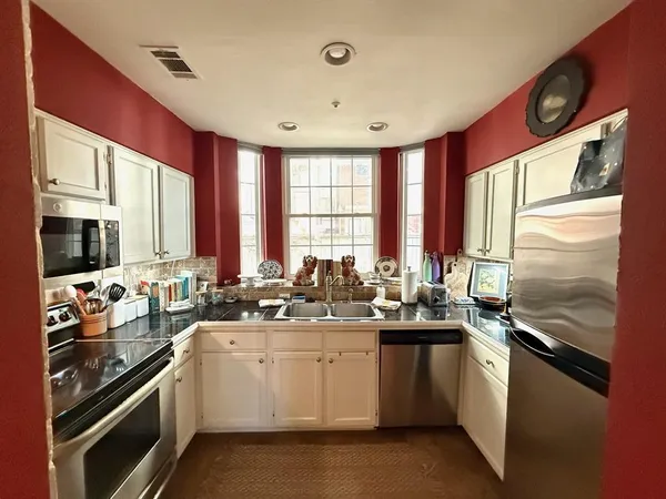 a kitchen with a sink stove top oven and cabinets