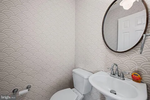 a bathroom with a sink mirror and toilet